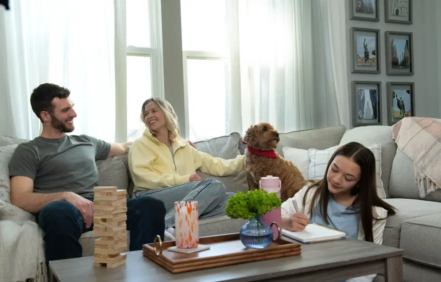Family relaxing on the couch at home with their dog