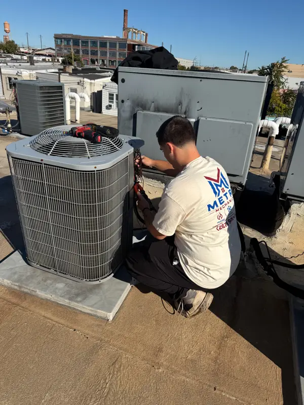 Metro Mechanical tech servicing a rooftop condenser